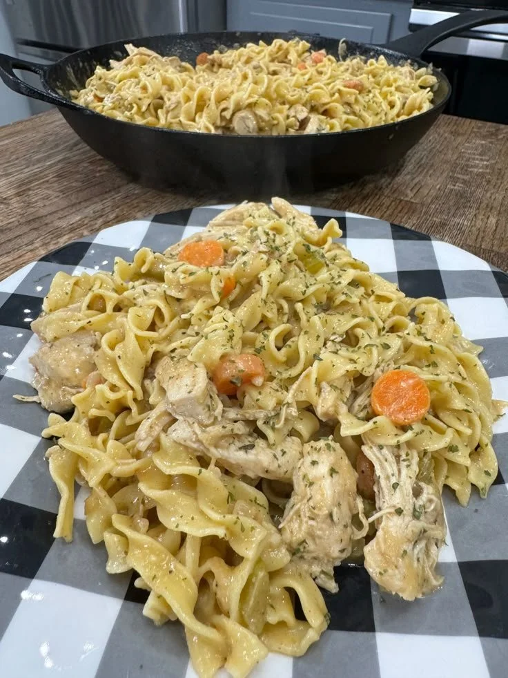Creamy chicken and noodles served in a bowl with herbs and spices.