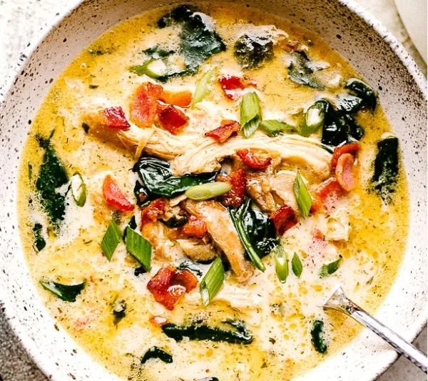 Bowl of creamy Crack Chicken Soup garnished with herbs.
