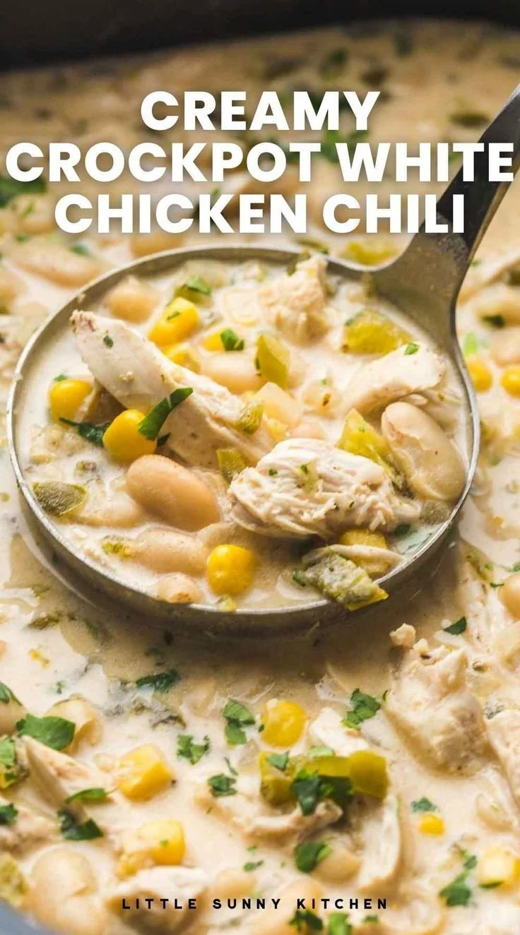 Bowl of creamy crockpot white chicken chili topped with fresh herbs
