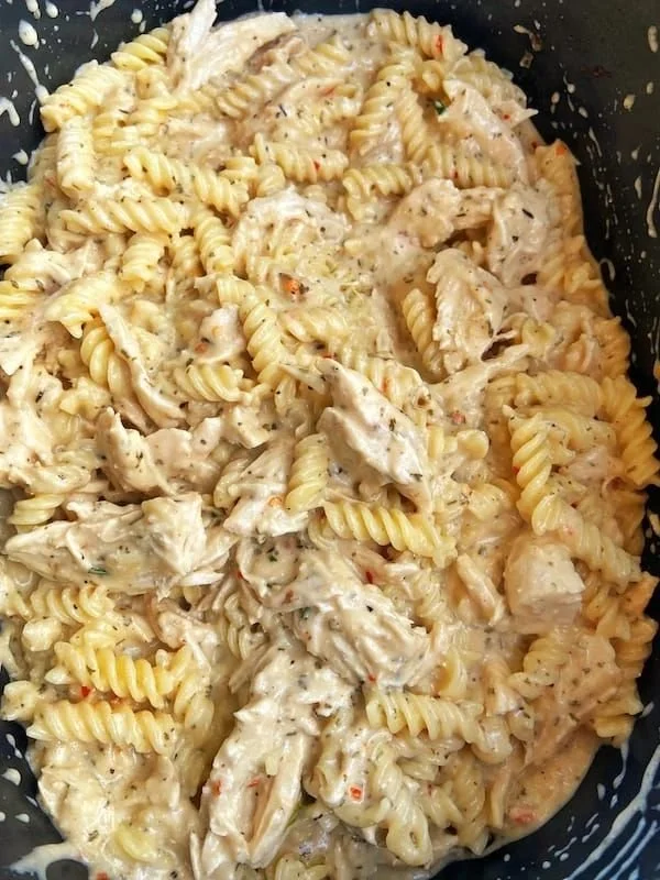 Crock Pot Garlic Parmesan Chicken Pasta served with fresh herbs and cheese