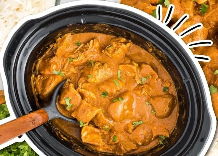 Delicious slow cooker butter chicken served with rice and garnished with cilantro