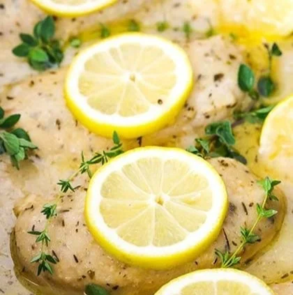 Slow cooker creamy lemon butter chicken dish garnished with herbs